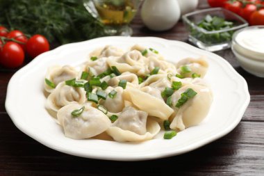 Tahta masada yeşil soğanlı leziz pelmeni, yakın plan.