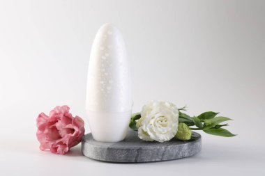 Beyaz arka planda rulo deodorant ve güzel Eustoma çiçekleri