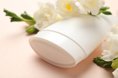 Katı deodorant ve güzel Eustoma çiçekleri bej arka planda, yakın plan