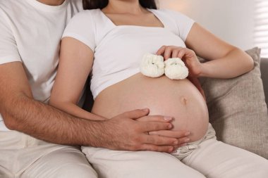 Bebek popolu hamile kadın ve kocası evde, yakın plan.