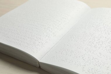 Tahta masanın üzerinde Braille metni olan bir kitap, yakın plan. Körler için eğitim ve eğlence