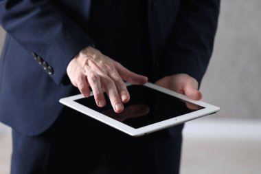 Kapalı alanda tablet kullanan bir iş adamı, yakın plan. Modern teknoloji