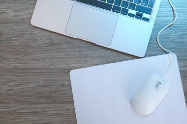 Fare başlı bilgisayar faresi ve dizüstü bilgisayarı tahta masanın üstünde, düz yatıyordu.