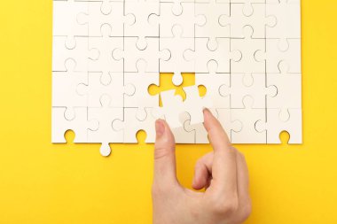 Sarı arka planda beyaz bulmacayı çözen kadın, yakın plan