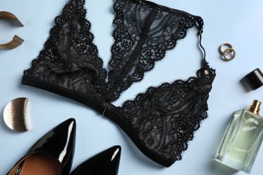 Açık mavi arkaplanda güzel dantel sütyen ve aksesuarlar, düz uzanmış.