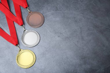 Gri arkaplanda altın, gümüş ve bronz madalyalar var. Metin için boşluk