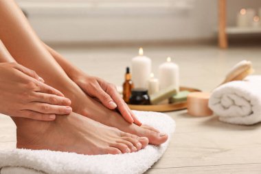 Bir kadın yerde ayaklarına dokunuyor, yakın plan. Vücut bakımı