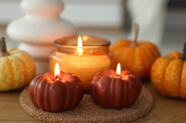 Ahşap masada mum ve balkabağı yakmak, yakın plan. Sonbahar atmosferi