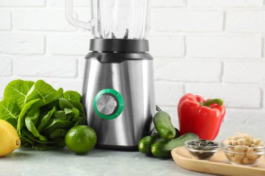 Blender ve ürünler beyaz tuğla duvara karşı ışık masasında