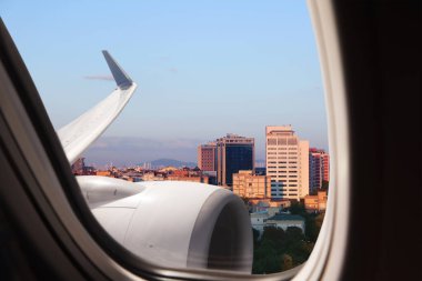 Airplane taking off or landing, view on city from window clipart