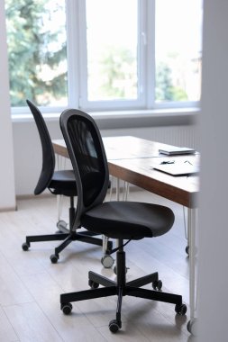 Siyah sandalyeler, dizüstü bilgisayarlar ve masa
