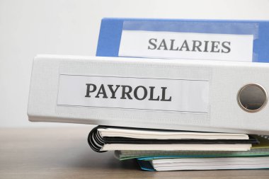 Sözcüklerle dolu ofis klasörleri Maaş ve maaşlar ahşap masada, yakın plan