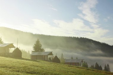 Bir sürü ev ve sabah sisle kaplı güzel dağlar.