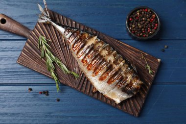 Lezzetli ızgara uskumru, biber ve biberiye ile ahşap masa, düz yatıyordu.