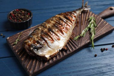 Lezzetli ızgara uskumru, biberiye ve ahşap masa, yakın plan.