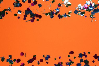 Turuncu arka planda parlak konfeti, üst manzara. Metin için boşluk