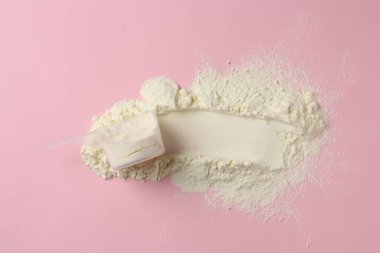 Protein tozu ve pembe arka planda kepçe, üst görünüm