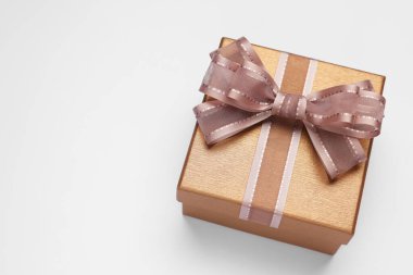 Açık gri arka planda fiyonklu hediye kutusu, üst tarafta. Metin için boşluk