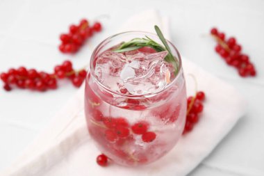 Kırmızı frenk üzümü ve beyaz fayanslı masada cam biberiye ile ferahlatıcı su, yakın çekim