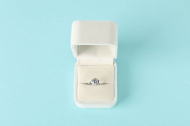 Açık mavi arkaplanda, üzerinde mücevher olan güzel bir yüzük.