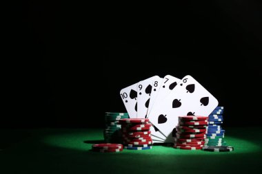 Poker çipleri ve iskambil kartları yeşil masada, metin için boşluk