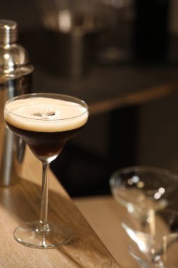 Bardaki ahşap masada nefis espresso martinili bir bardak.