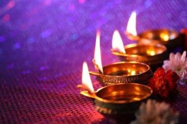 Diwali kutlaması. Diya lambaları ve arka planda güzel çiçekler, yakın plan. Metin için boşluk