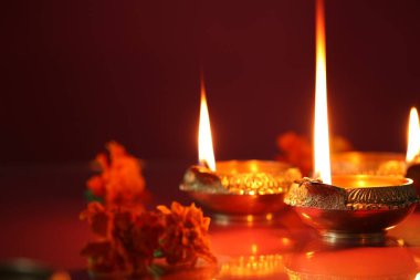 Diwali kutlaması. Diya lambaları ve arkaplanda güzel çiçekler, yakın plan