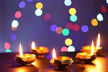 Diwali kutlaması. Karanlık masada bulanık ışıklara karşı Diya lambaları