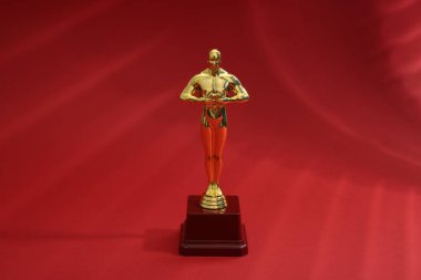 Kırmızı arka planda bir Altın Oscar ödülü