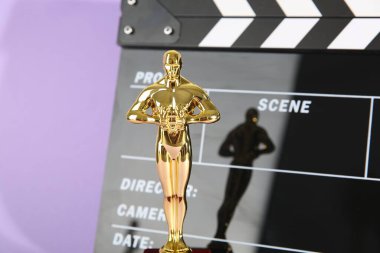 Altın Oscar ödülü ve menekşe arka planda film alkışları