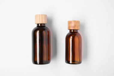 Beyaz arka planda şişelerde gerekli yağlar, üst görünüm