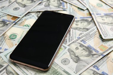 Dolar banknotları üzerinde modern akıllı telefon, yakın çekim görüntüsü