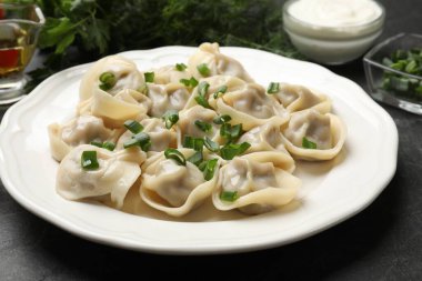 Gri desenli masada yeşil soğanlı leziz pelmeni, yakın plan.