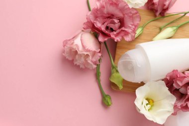 Yuvarlak deodorant ve pembe arka planda güzel Eustoma çiçekleri, üst manzara. Metin için boşluk