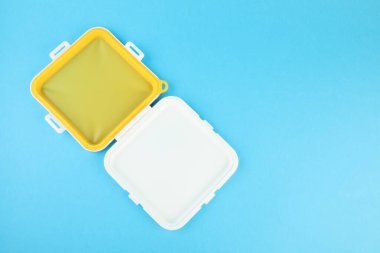 Açık mavi arka planda boş sandviç kutusu, üst manzara. Metin için boşluk