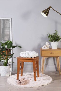 Odasında düğüm yastığı olan ahşap tabure. Şık iç tasarım