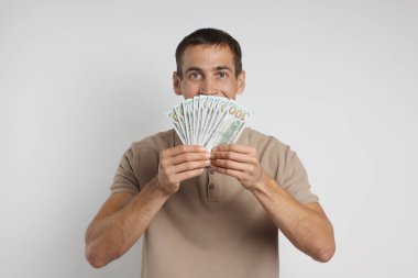 Beyaz arka planda dolar banknotları olan adam.