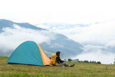Sırt çantalı ve çadırlı genç kampçı dağlarda, yazı için yer var.