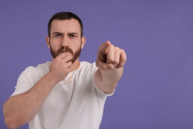 Mor arka planda ıslık çalan genç adam, metin için boşluk