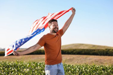 Amerika bayrağı taşıyan mutlu bir adam.