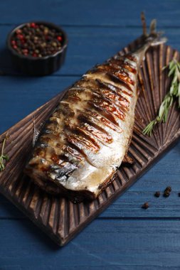 Lezzetli ızgara uskumru, biberiye ve ahşap masa, yakın plan.