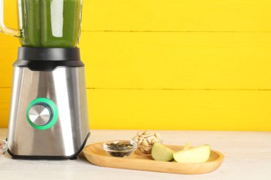 Buzlu modern blender ve hafif ahşap masada malzemeler. Metin için boşluk