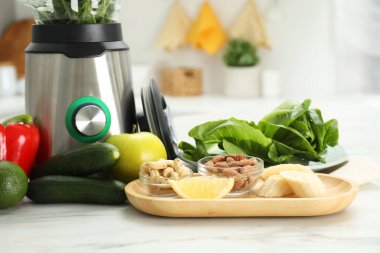 Mutfaktaki beyaz mermer masada smoothie için malzemeler içeren modern blender, yakın plan.
