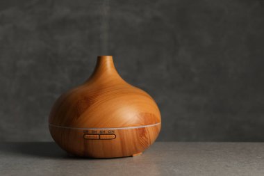 Açık gri masa üzerinde buharı olan Aroma yağı ayırıcı, metin için boşluk