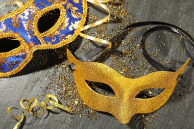 Güzel karnaval maskeleri ve konfeti gri desenli masada, düz yerde.