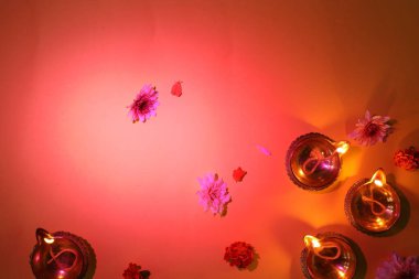 Diwali kutlaması. Diya lambaları ve güzel çiçekler kırmızı arka planda, düz yatıyordu