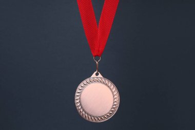Koyu gri arka planda kırmızı kurdeleli bronz madalya