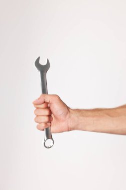 Açık gri arkaplanda ingiliz anahtarı olan oto tamircisi, kapat
