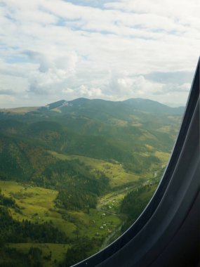 Airplane flying over mountains, beautiful view from window clipart